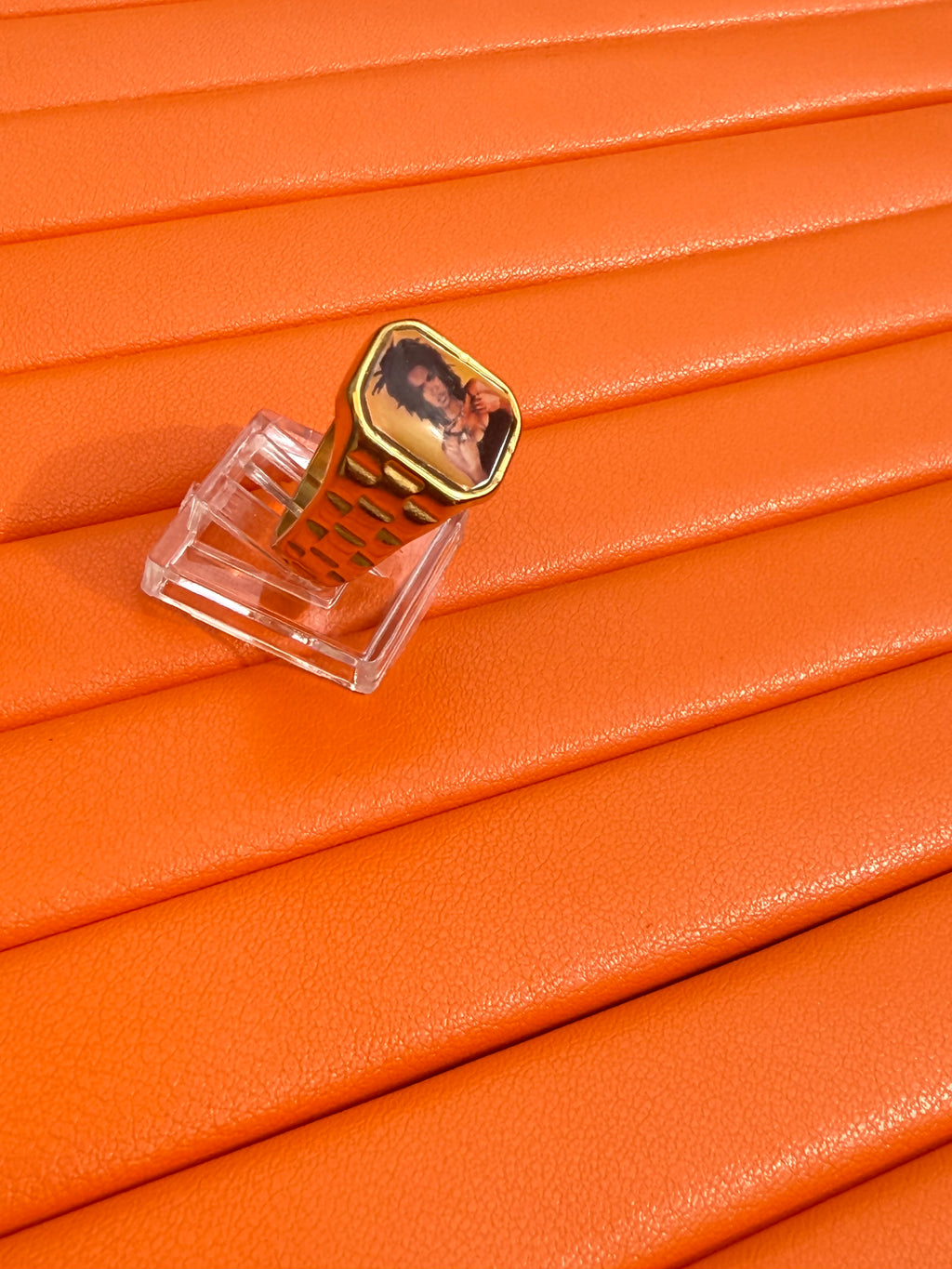 18K gold-plated Lauryn Hill-inspired Lav Vintage promise ring with square face, photographed on an orange background.
