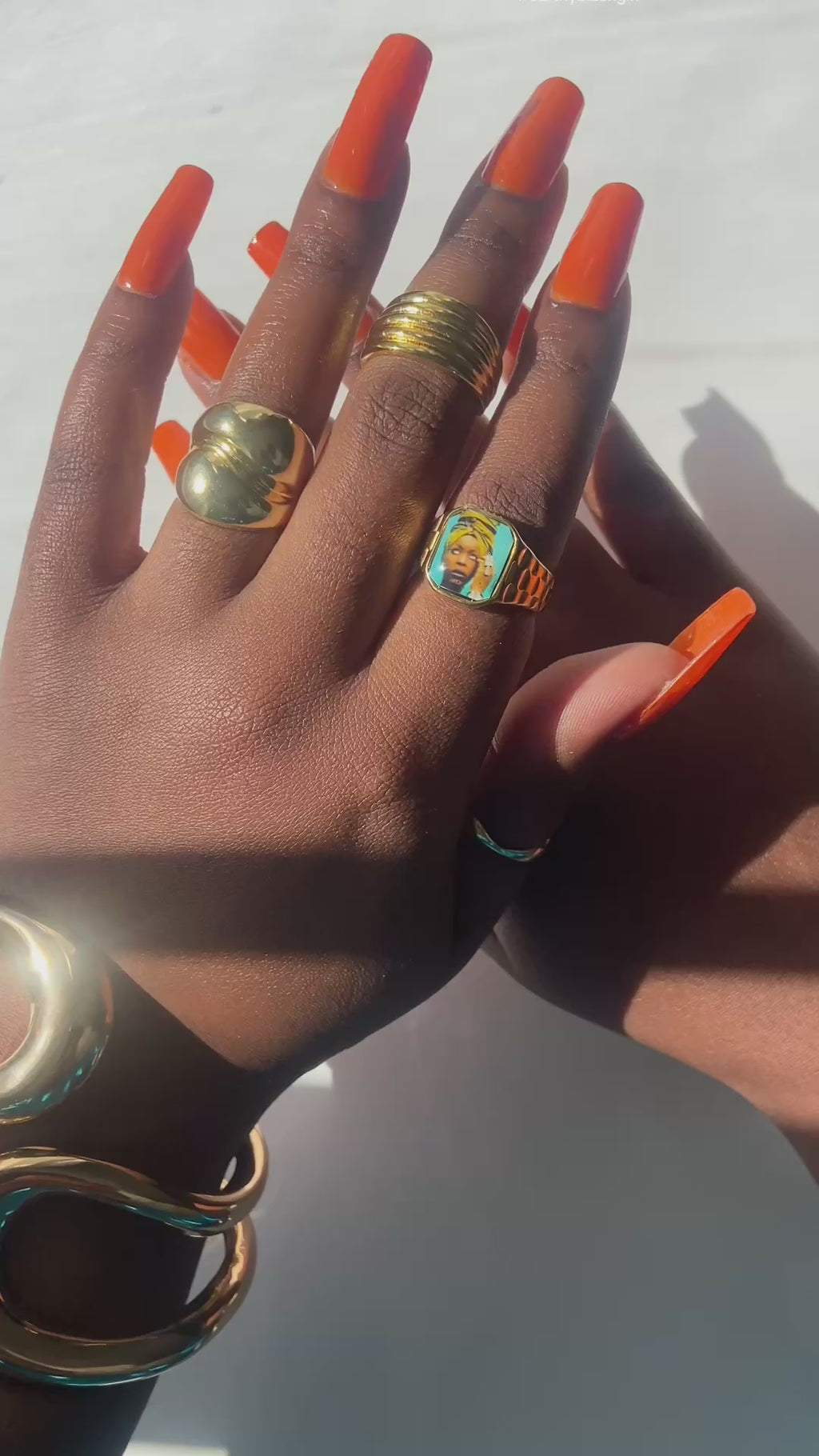Video showing Hand wearing stacked gold rings including an Erykah Badu-inspired Lav Vintage promise ring, styled in natural sunlight.